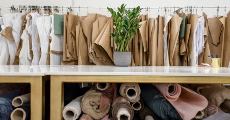 Material Choice - Rolls of assorted fabrics and textiles and sewing patterns inside tailor atelier